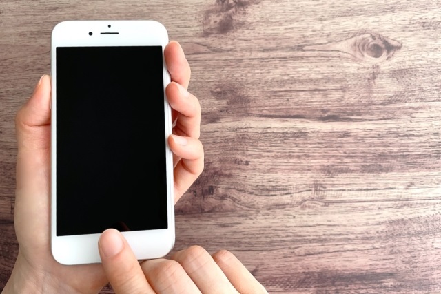 スマホのボタンを押す指